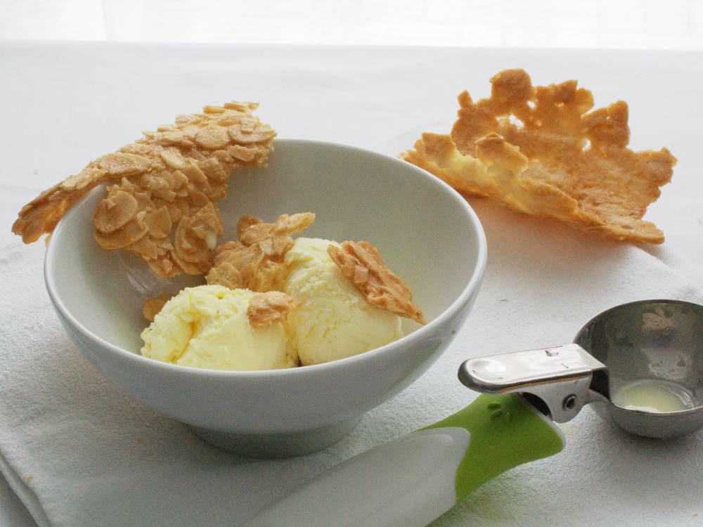 recette de tuiles aux amandes en morceaux sur une boule de glace vanille